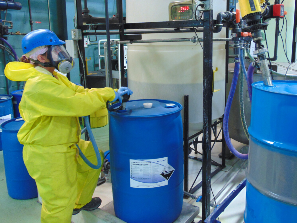 A Miura employee in PPE fills a Boilermate barrel